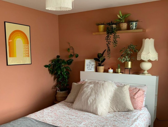 murs couleur terracota dans une chambre à coucher avec du linge maison confortable