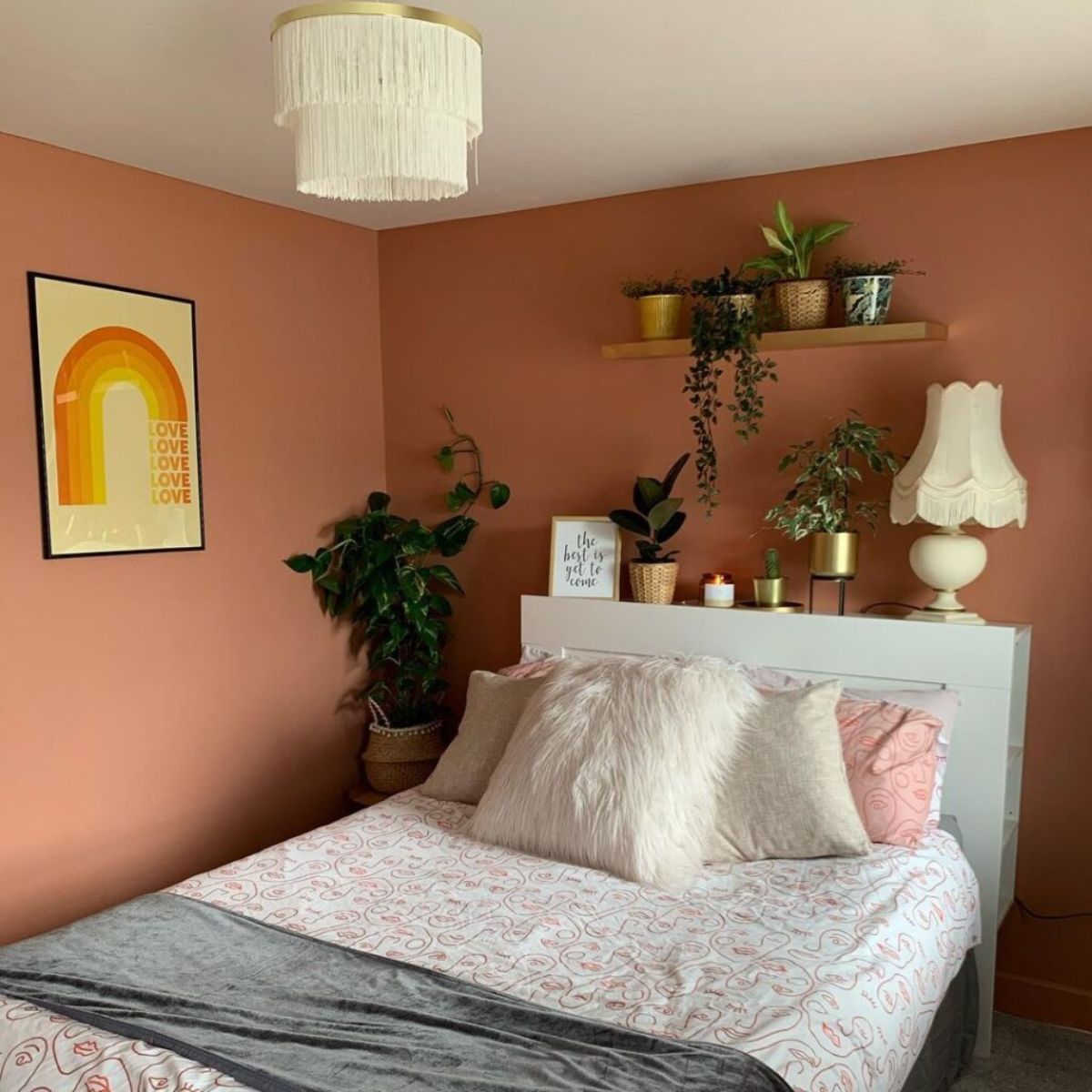 murs couleur terracota dans une chambre à coucher avec du linge maison confortable