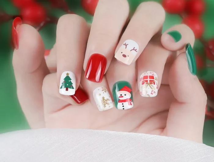 ongles noel en blanc vert et rouge avec un arbre de noel un bonhmme de neige rudolph le cerf un cadeau et des flocons dorés