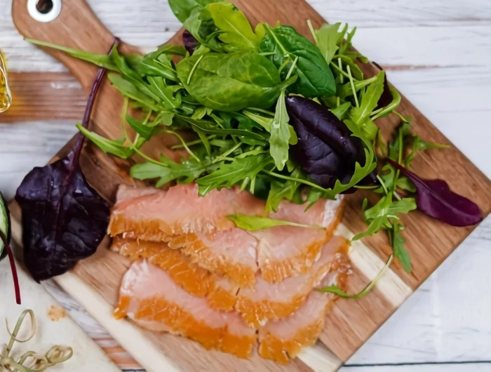 saumon fume et salade sur une planche en bois