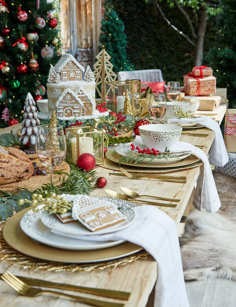 table d enoel chic en bois couverts or vaisselle blanche bougeoirs deco florale