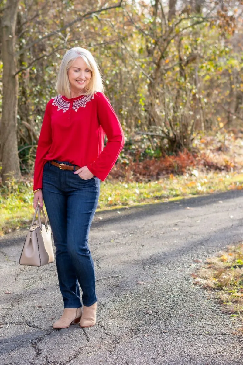tenue chic femme 50 ans jean et top rouge avec des strass chaussures à talon sac à main gris