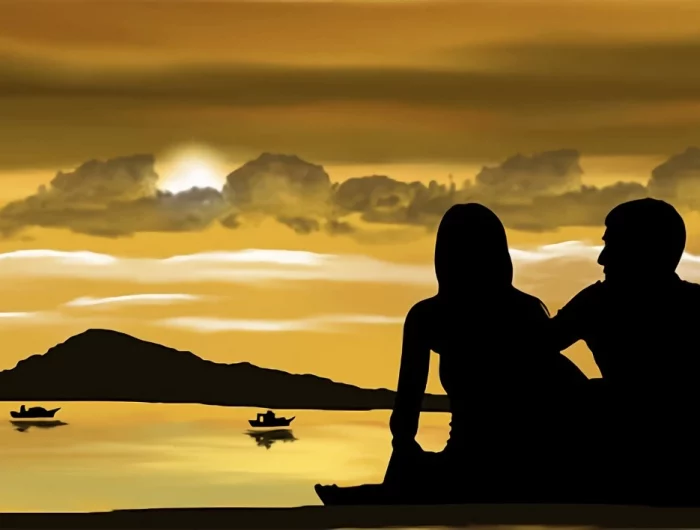 un couple en ombre face au soleil sous nuages au bord de la mer en fond un paysage calme avec deux barques