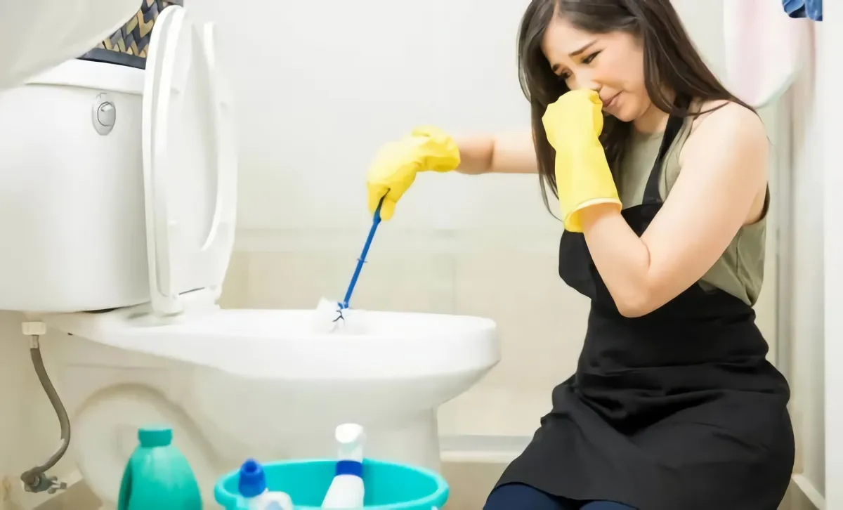 astuces de grand mère pour se débarrasser des mauvaises odeurs de canalisation femme se serre le nez aux toilettes