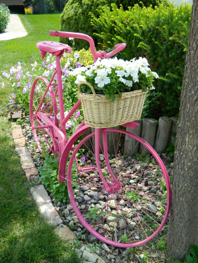 contenants originaux pour plantes velo rose avec panier plein defleurs dansun jardin