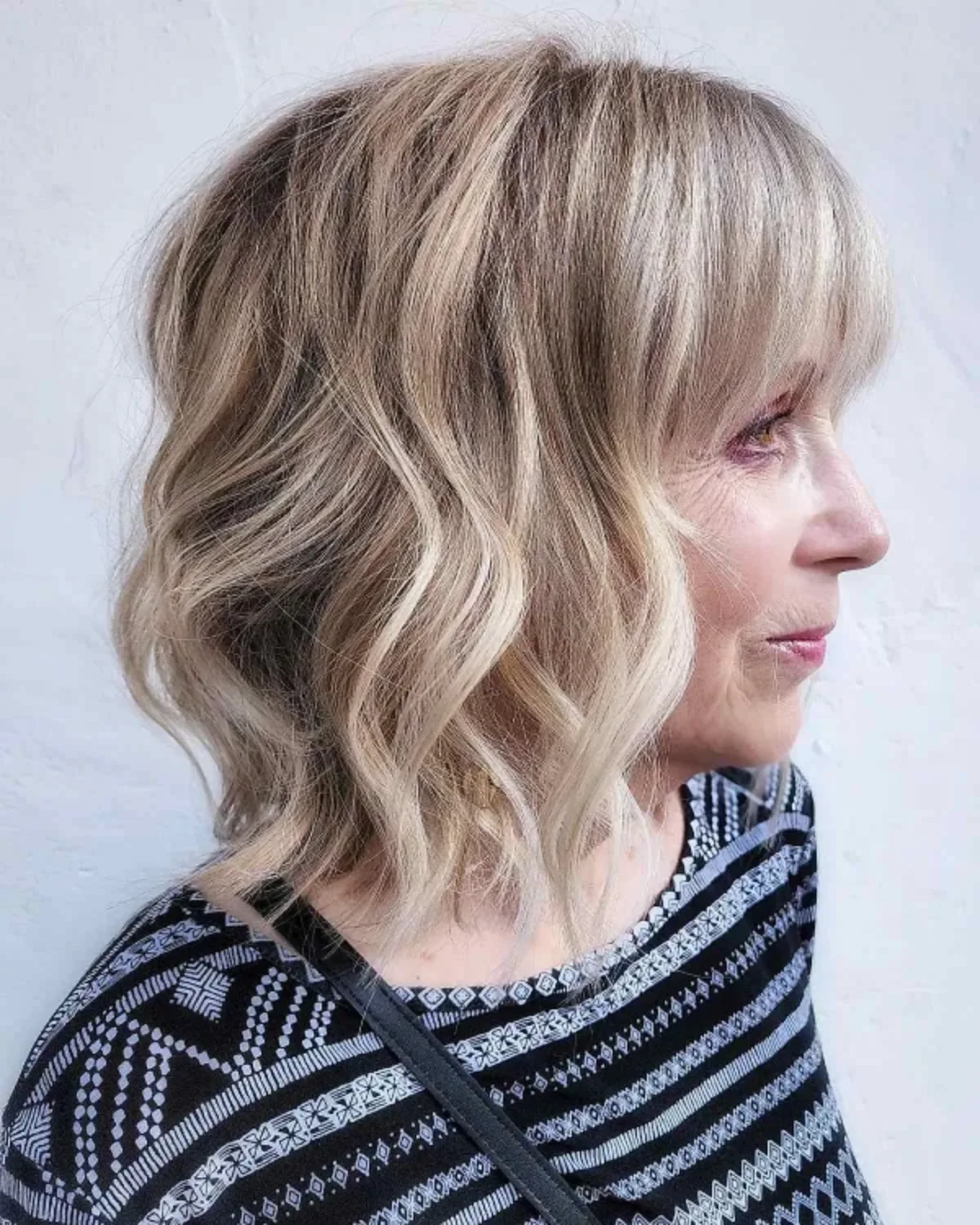 coupe de cheveux femme 60 ans avec frange et des mèches ondulées