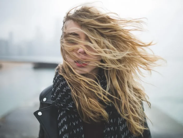 femme avec cheveux blonds dans le vent