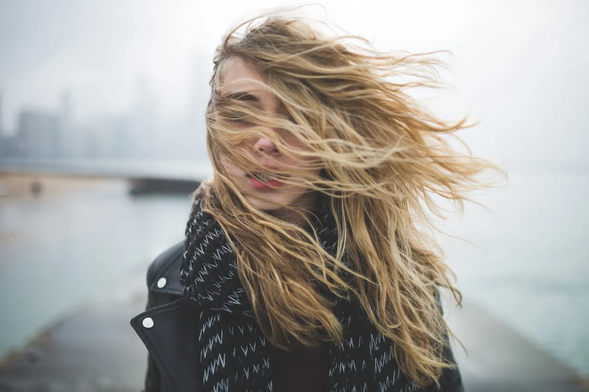 femme avec cheveux blonds dans le vent