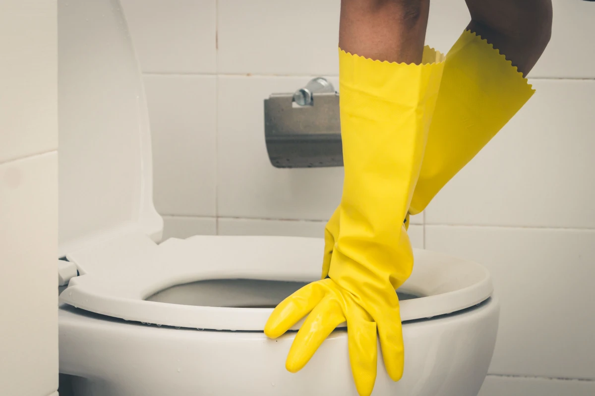 gants jaunes cuvette blanche toilettes bouchees