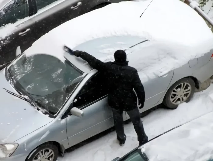 la mailleur facon enlever la neige de votre voiture pas a pas avec une vue de dessus un homme qui nettoie sa voiture