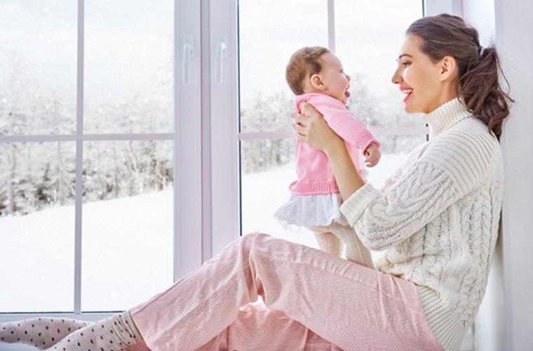 un climatiseur haut de gamme est une solution économique pour se chauffer en hiver femme avec unenfant ala fenetre