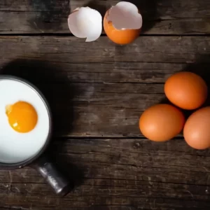 une mini poele avec un œuf a plat avec sa coquille cassee et trois œufs entiers