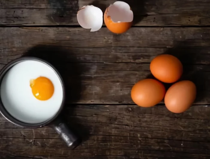 une mini poele avec un œuf a plat avec sa coquille cassee et trois œufs entiers