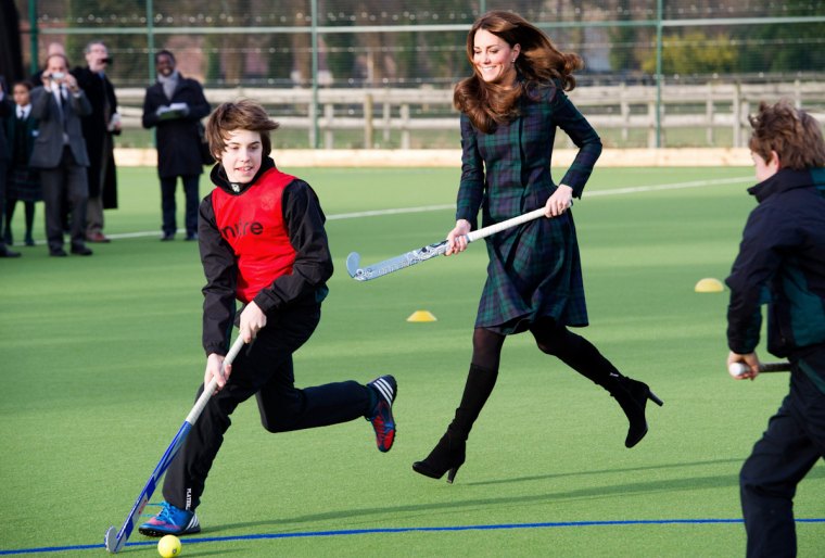 kate middletown court avec ses talons hauts en jouants avec des enfants sur un terrain vert