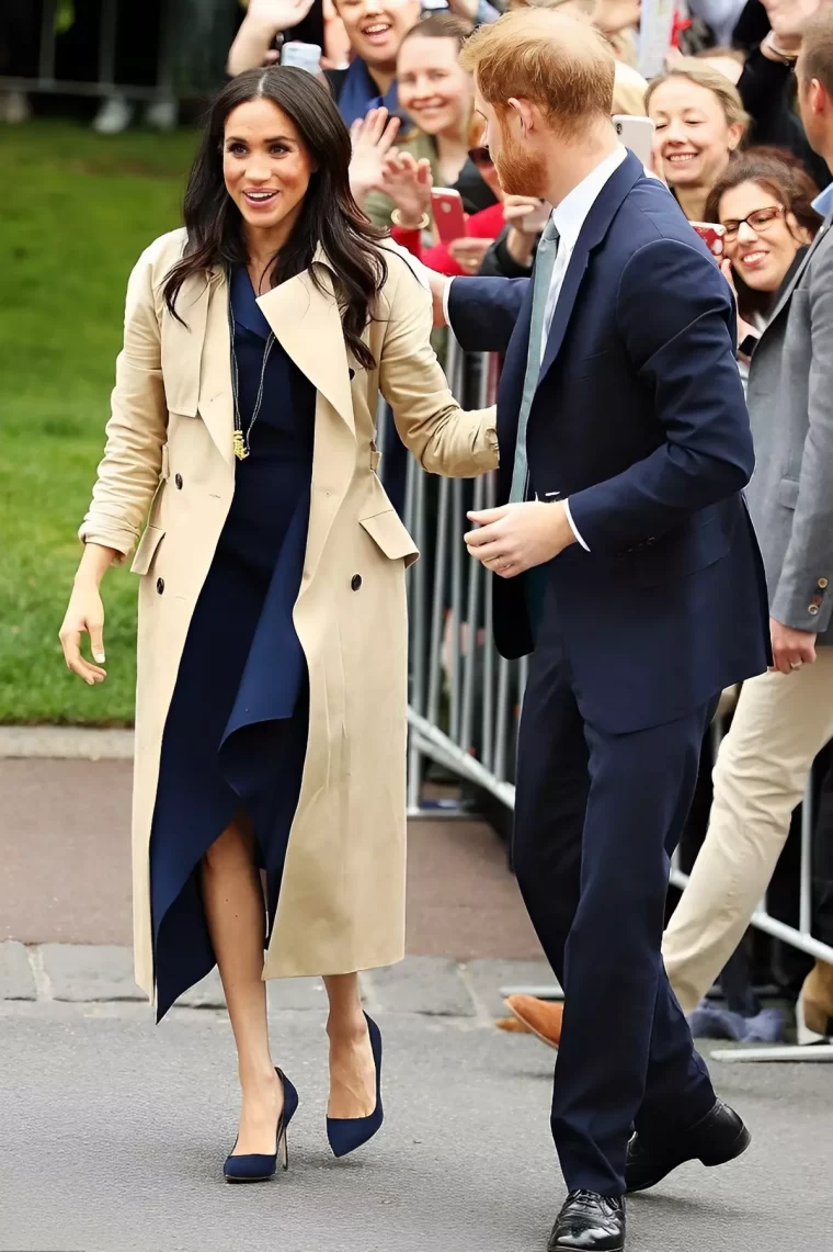 meghan markle souriante avec harry tourne vers elle ensemble devant en public