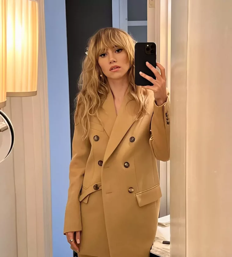 selfie dans un miroir montrant une femme aux cheveux blonds et tres longs avec une coupe shag