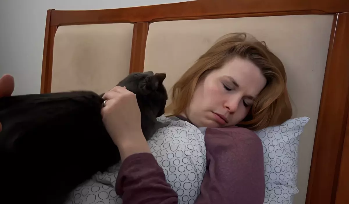 un chat noir dormant sur sa propriétaire