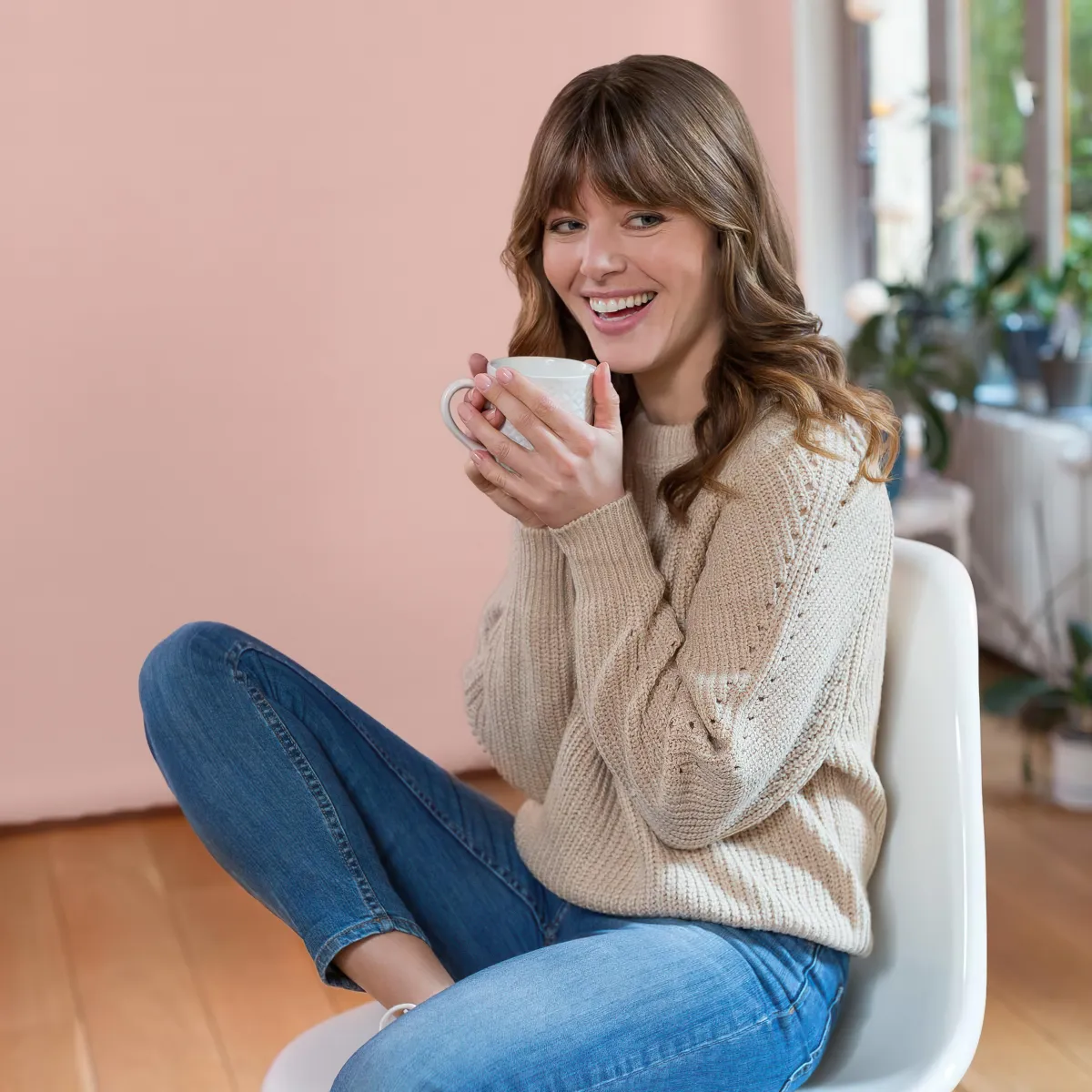 femme en jean bleu et pull beige cheveux mi longs ondules