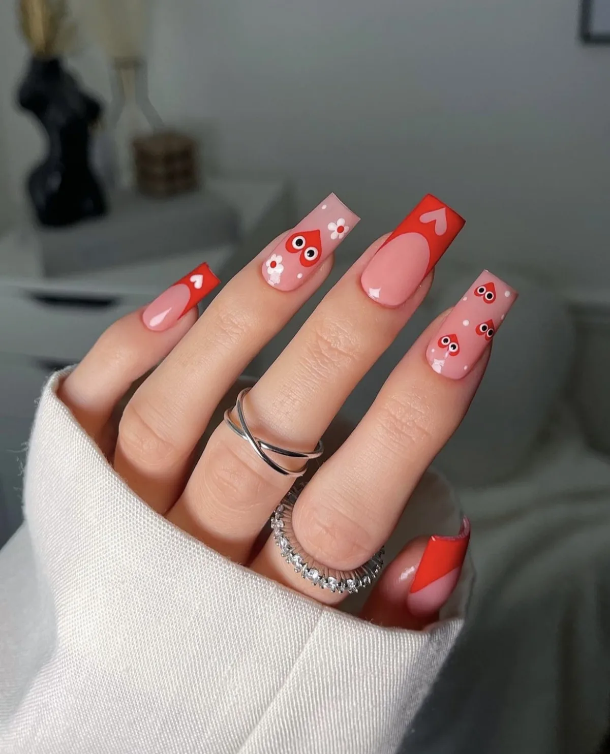 nail art ongle rouge avec des motifs ludiques et des motifs rose