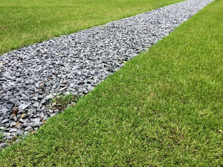 une allee avec des graviers et pelouse verte