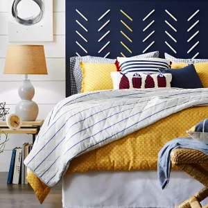 une tete de lit bleu nuit a motifs avec un lit et beaucoup de coussins colores