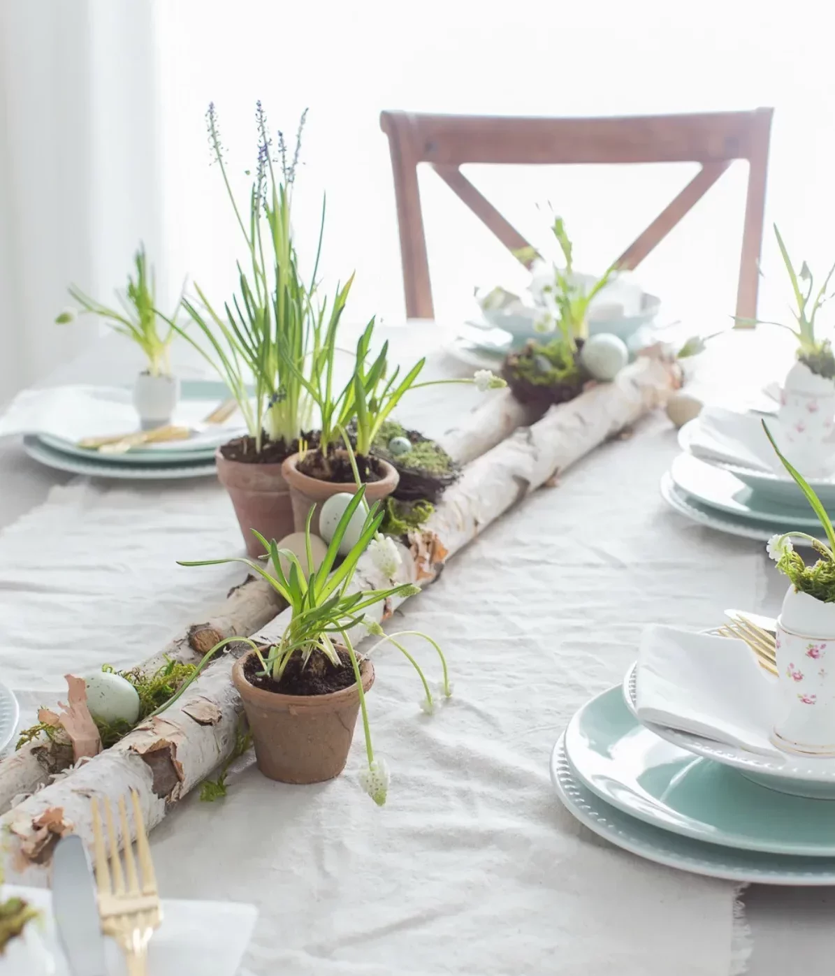 centre de table paques original en branche de bois récup et petits pots de fleuris