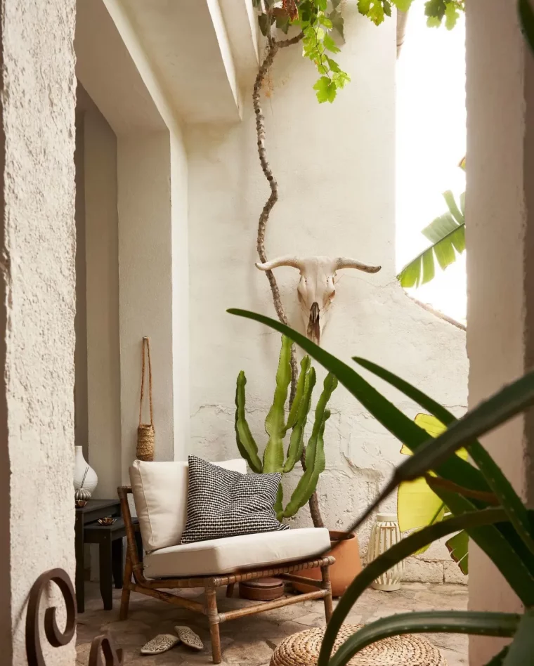 fauteuil de jardin en rotin entouré de plantes exotique deco salon de jardin ikea