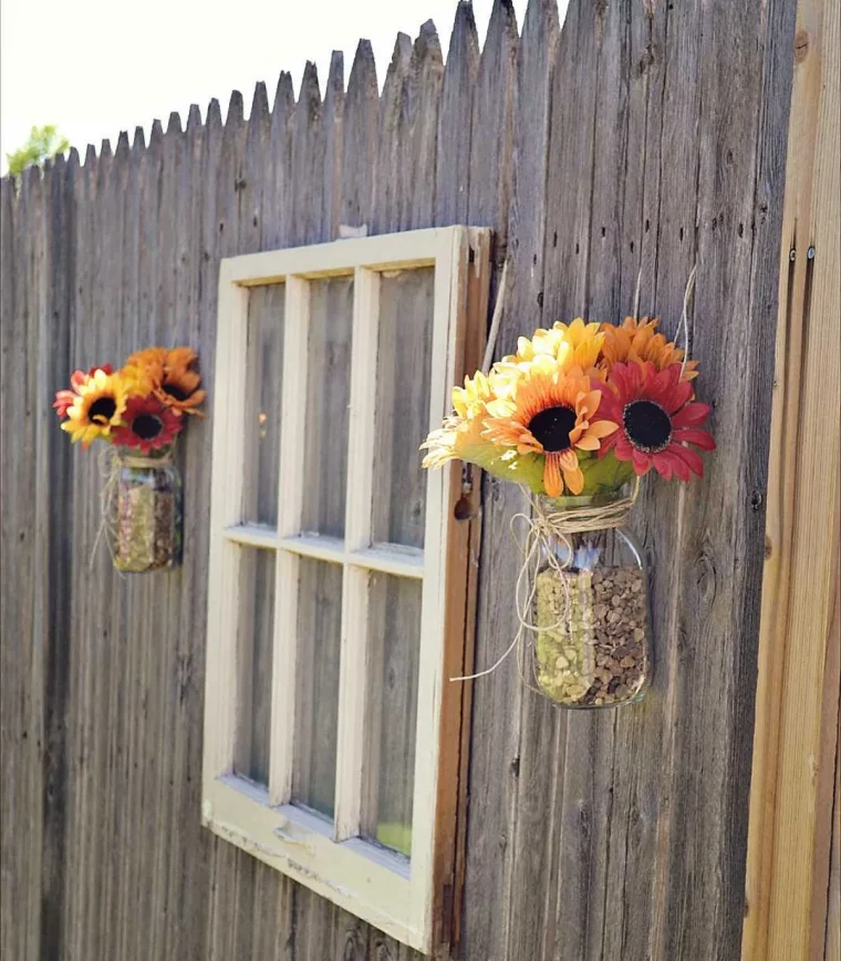 idée clôture jardin décoré d encadrement fenêtre et pots en verre avec de petits bouquets