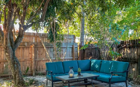 jardin paysager sans entretien avec gravier terrasse de dalles de pierre table basse et meuble canapé d angle cloture de bois