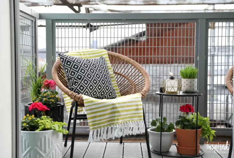 chaise tressée et pots de fleurs sur un petit balcon étroit