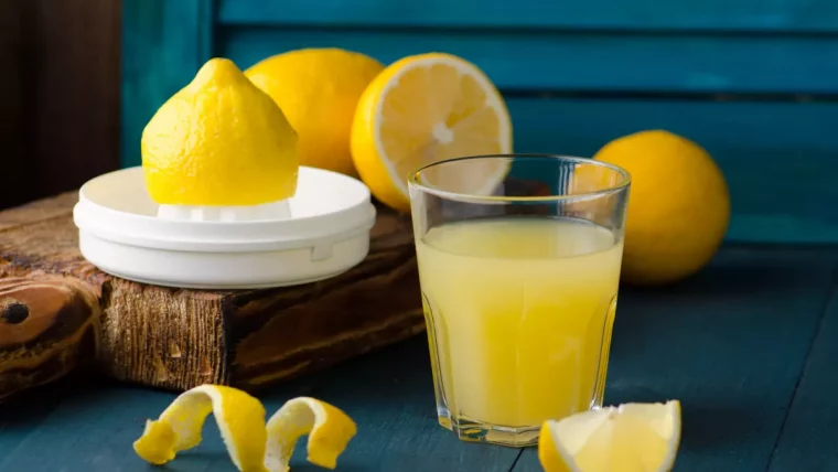 citron dans un presse citron avec un verre de jus