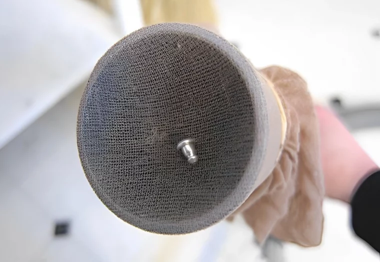 collant beige utilise comme filtre sur le tube de l aspirateur avec un petit objet en metal