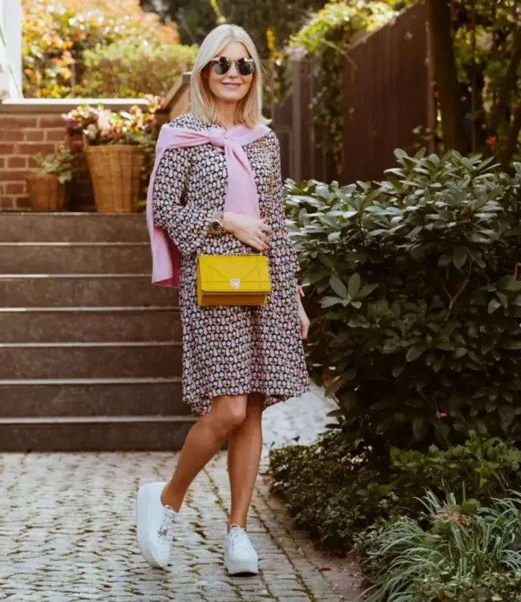 des sneakers blanches avec tailleur jupe et pull rose