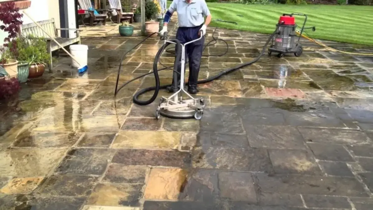 homme nettoyant sa terrasse avec brosse rotative enlever mousse