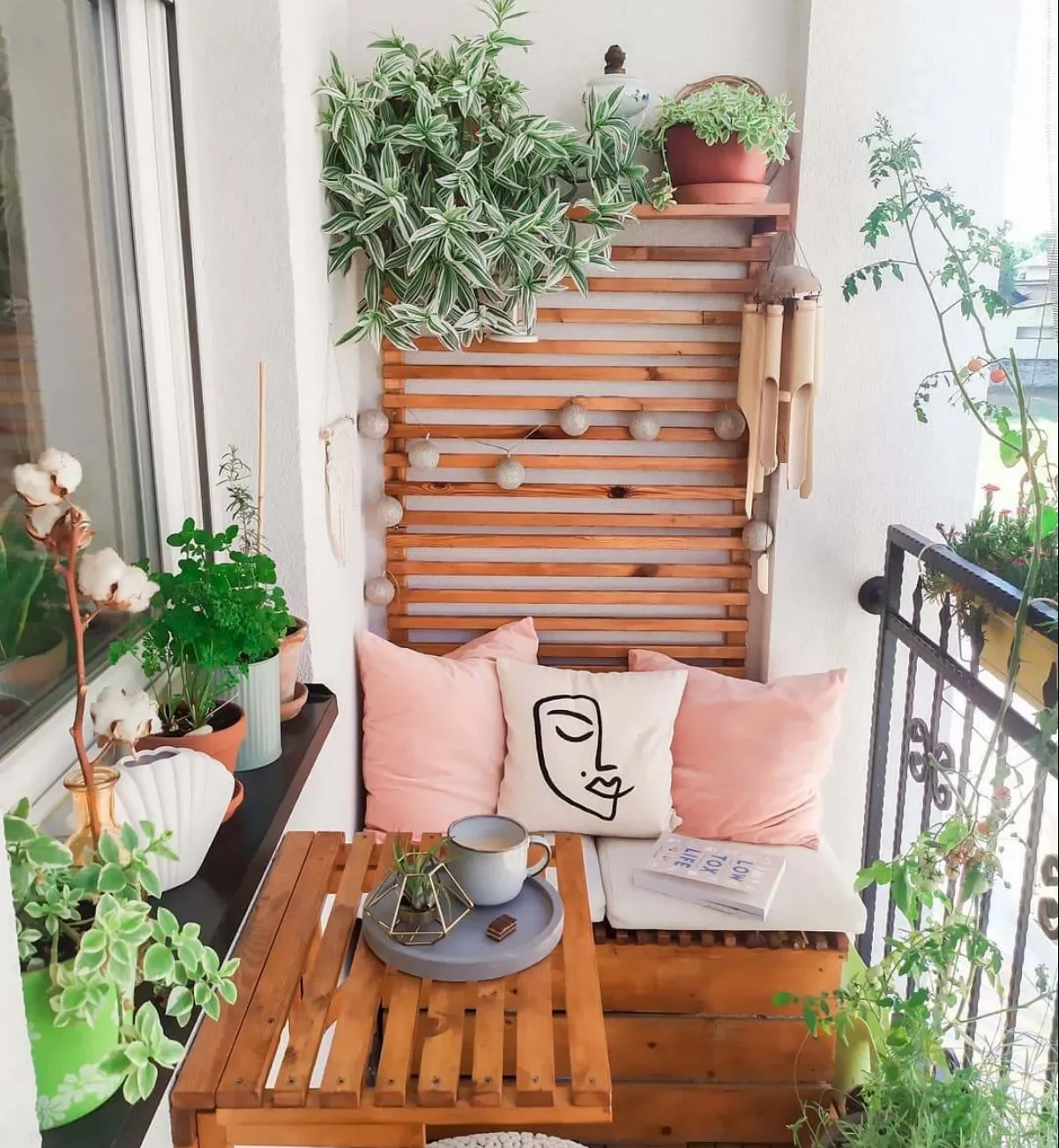 idée aménagement balcon assise en palette table suspendue coissins decoratifs plantes en pot