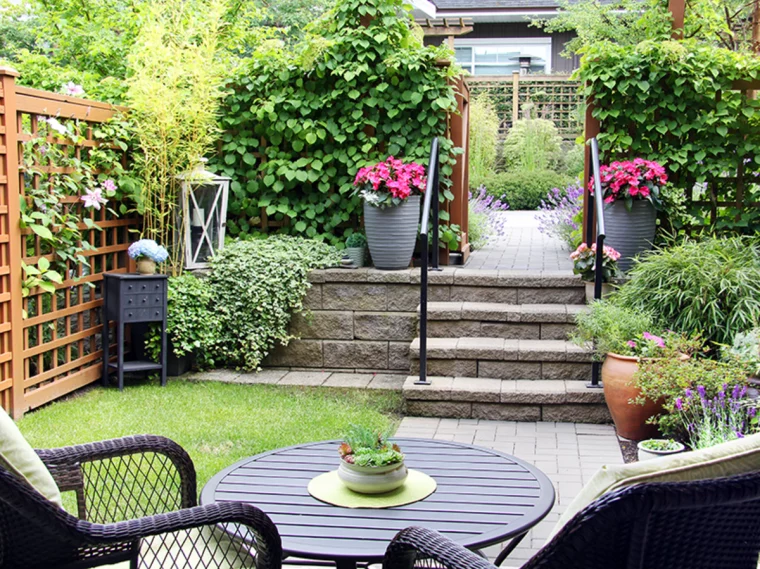 jardin paysager avec fleurs en pot et mobilier de jardin chaise et table