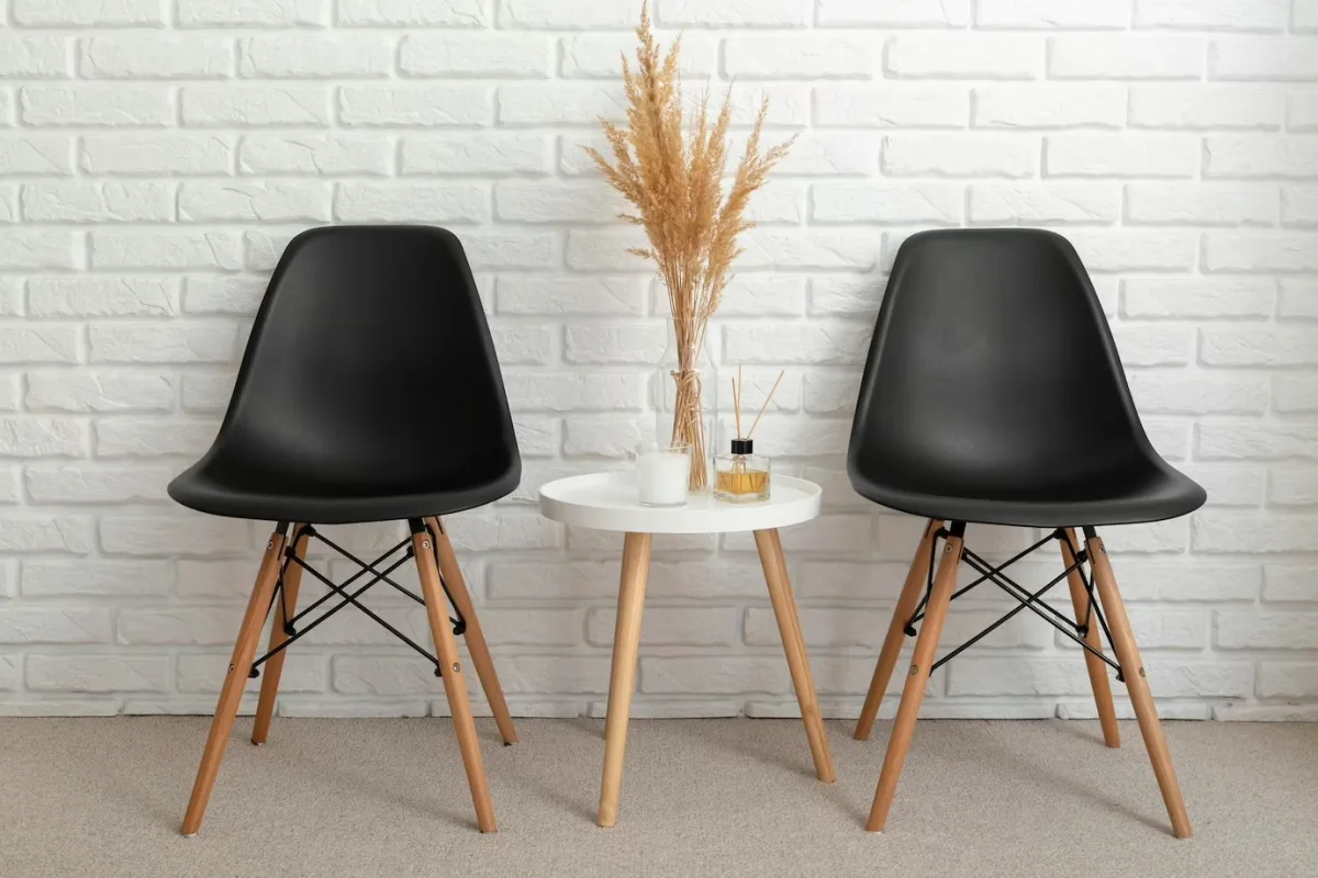 murs aspect briques blanches table bois ronde chaise noir mat pieds bois
