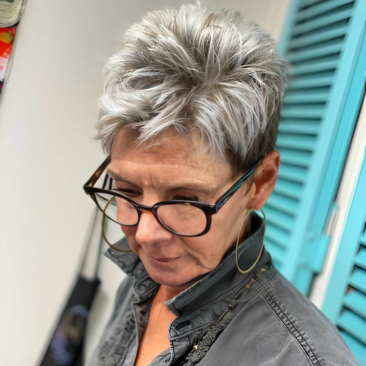 pixie court cheveux gris blanc rases sur cote coupe de cheveux femme 70 ans avec lunettes