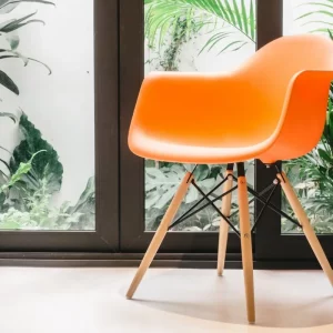 plantes vertes fenetres rideaux gris fonce chaise orange plastique pieds bois