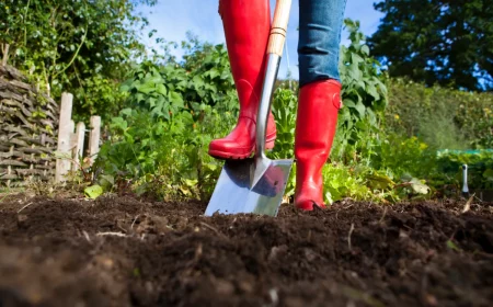 retourner la terre avant de semer un jardinier aux bottes rouges