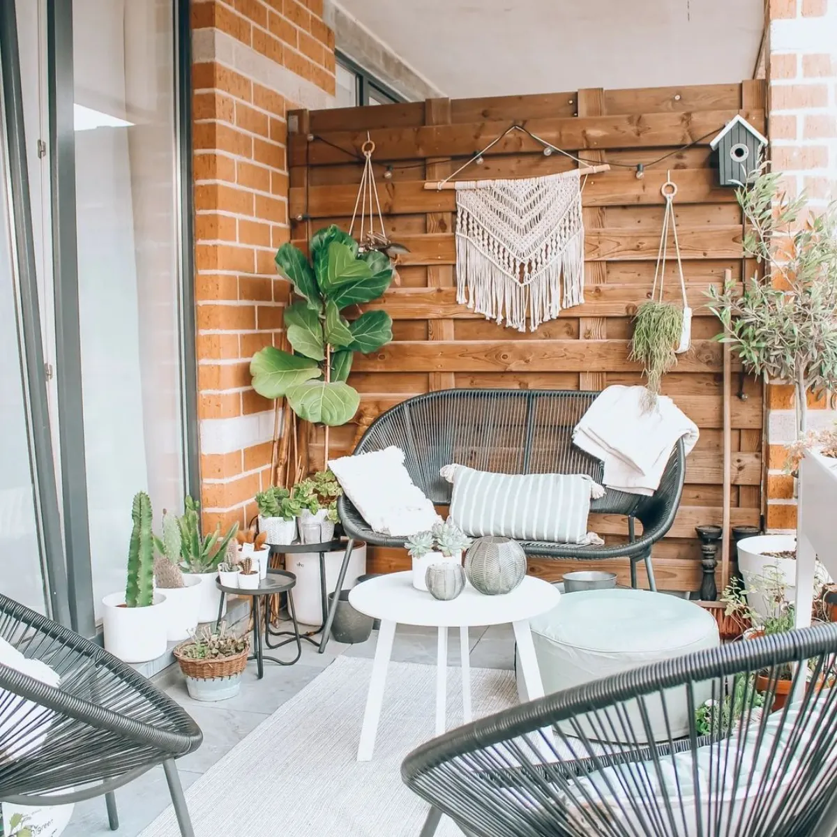 salon de jardin en metal aec canapé fauteuils table minimaliste mur de palette de bois