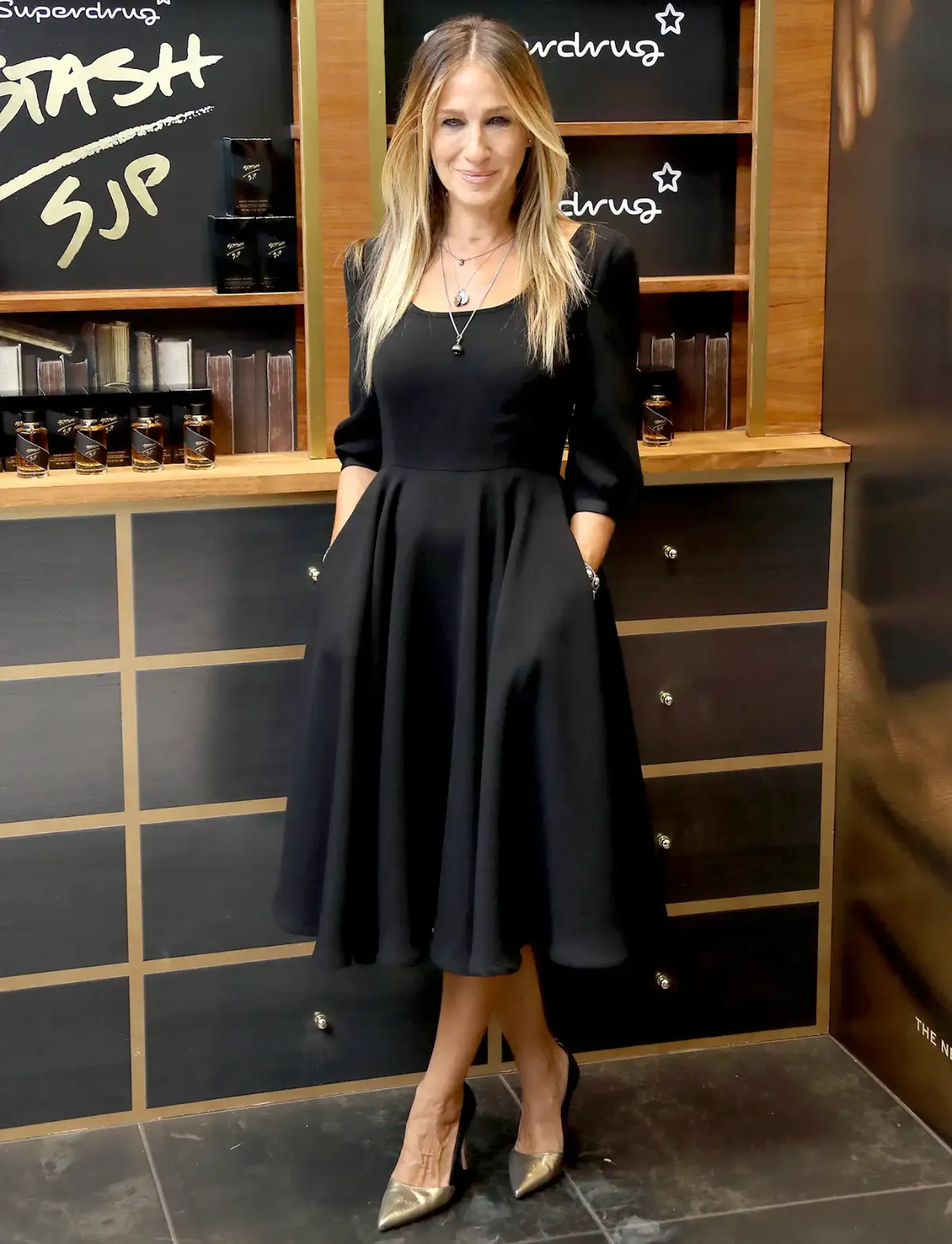 sarah jessica parker avec une robe noire évasée décolleté arrondi femme moderne 50 ans