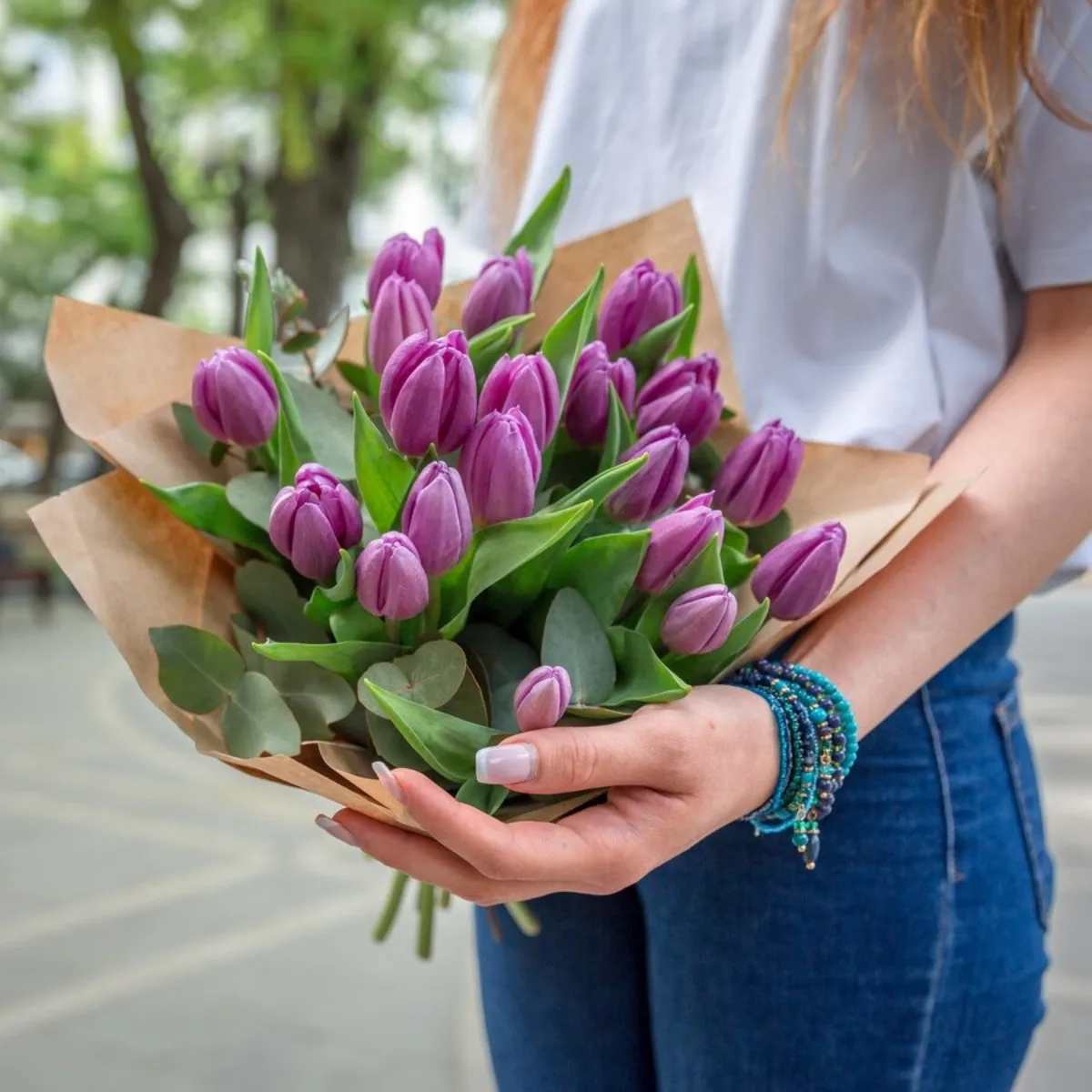 bouquet de tulipes violettes papier floriste femme t shirt blanc jeans manucure francaise