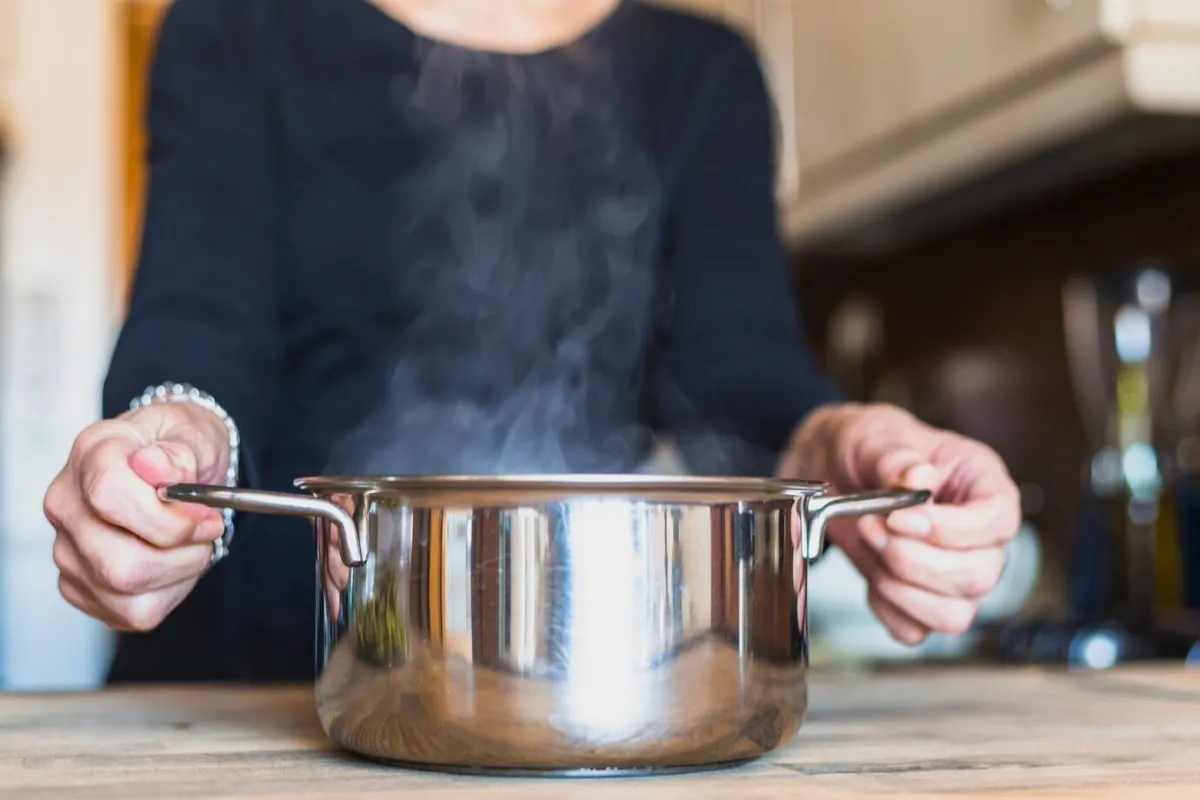 casserole eau bouillante cuisson femme cuisine main surface bois