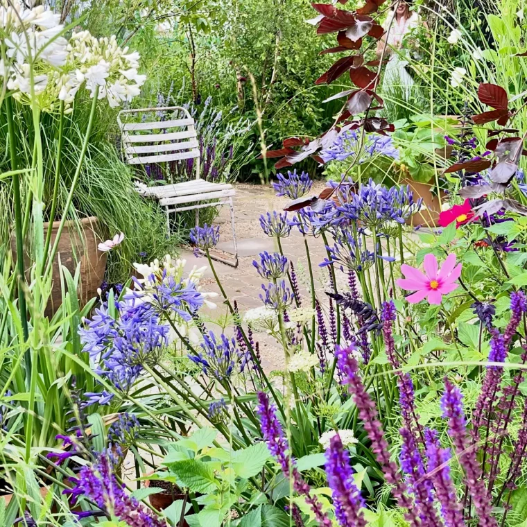 chaise en metal blanc dans le jardin massif de feurs