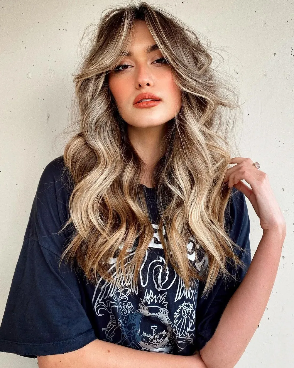 coupe cheveux femme avec frange rideau et mèches blonds étée 2023