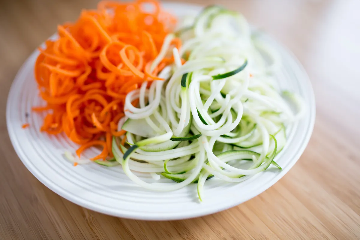 spagettis legumes nouilles courgettes carrottes assiette plate blanche surface bois