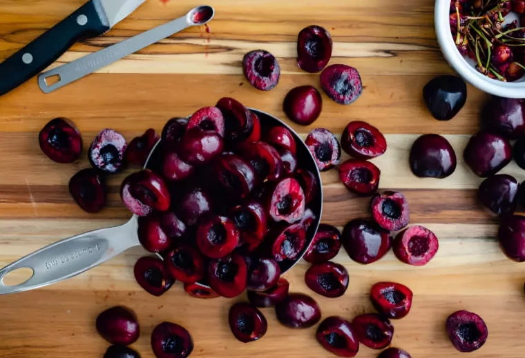 cerises coupees en deux et denoyautees avec un ustensile pour les petits noyaux