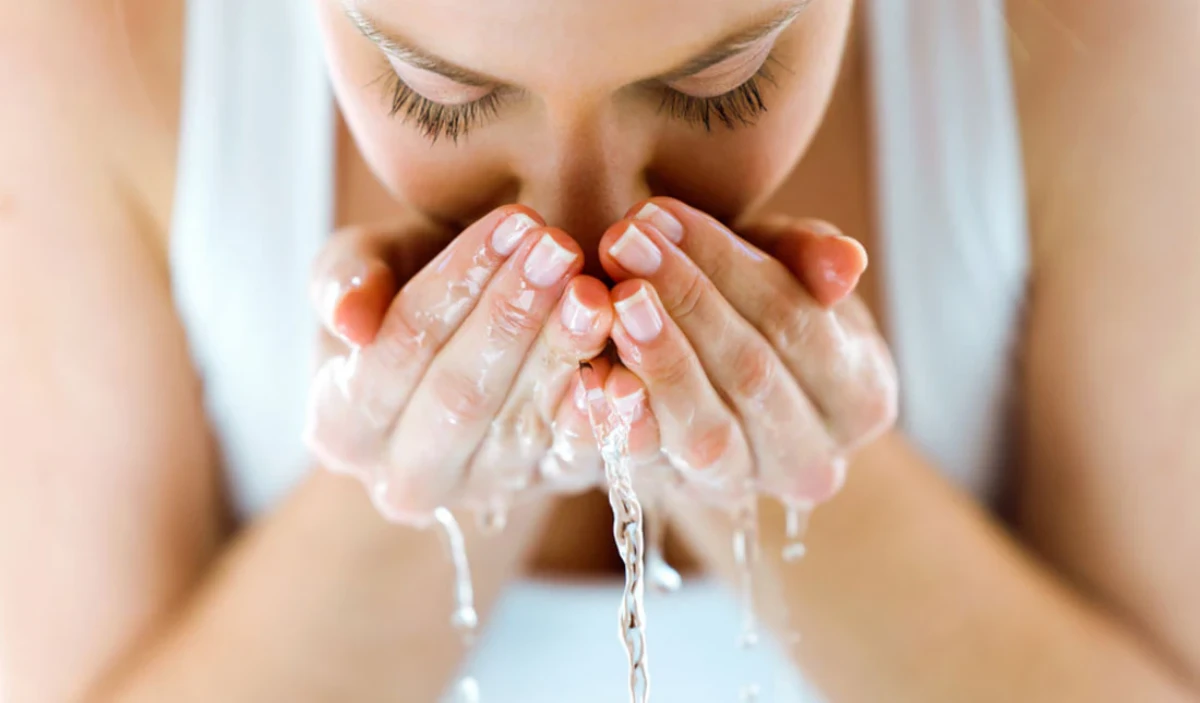 eau pour purifier les energies femme se lave le visage