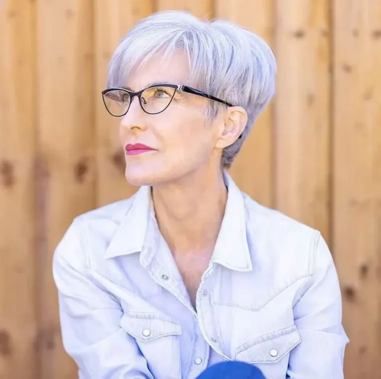 femme avec coupe courte en chemise blanche devant mur en bois